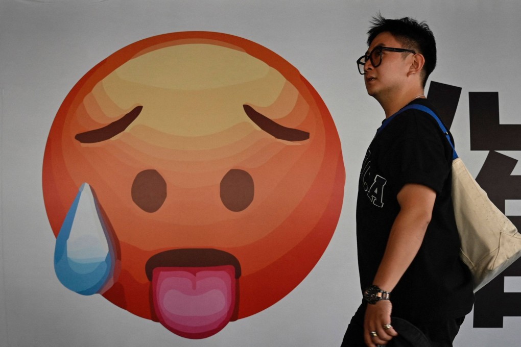 A man walks past an emoji at a shopping mall in Beijing on July 20. While the chances are good that the Chinese economy can hit the expected 5 per cent annual growth target, the government may have to step in more forcefully to nudge growth back on track. Photo: AFP