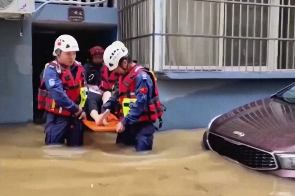 Rescuers aid a resident in a flood-hit village in eastern China’s Zhejiang province on Sunday.  Photo: CCTV via AP