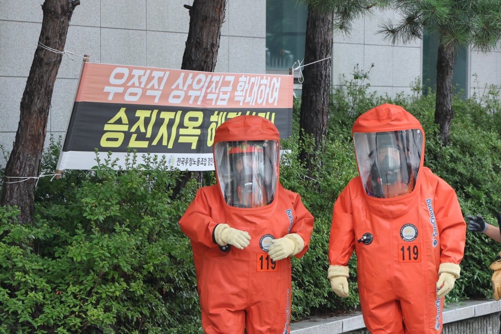 Firefighters wearing protective gear arrive at a post office northeast of Seoul, South Korea on Friday, after a suspicious package was found there. Photo: EPA-EFE/Yonhap