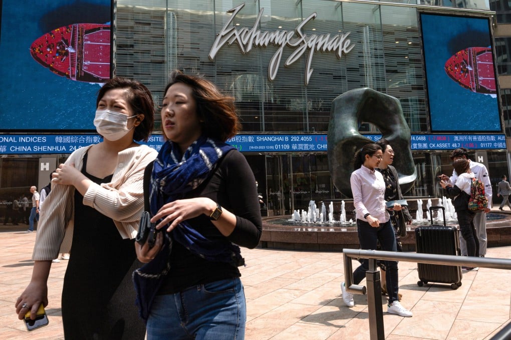 Women walk past a stock ticker outside Exchange Square, the building housing the stock exchange, in Hong Kong, on March 16. The city has an opportunity to seek out more women to join the workforce. Photo: EPA-EFE