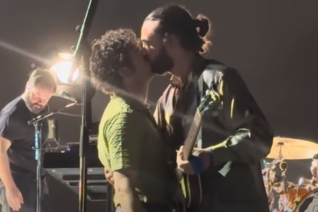 The 1975 singer Matty Healy kisses bandmate Ross MacDonald during a concert in Kuala Lumpur, Malaysia, in July 2023. The singer’s onstage LGBTQ-related rant raises questions about tourists visiting less tolerant countries than their own.
