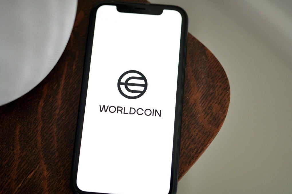 The Worldcoin logo is seen on a smartphone in this arranged photo taken in New York, July 24, 2023. Photo: Bloomberg
