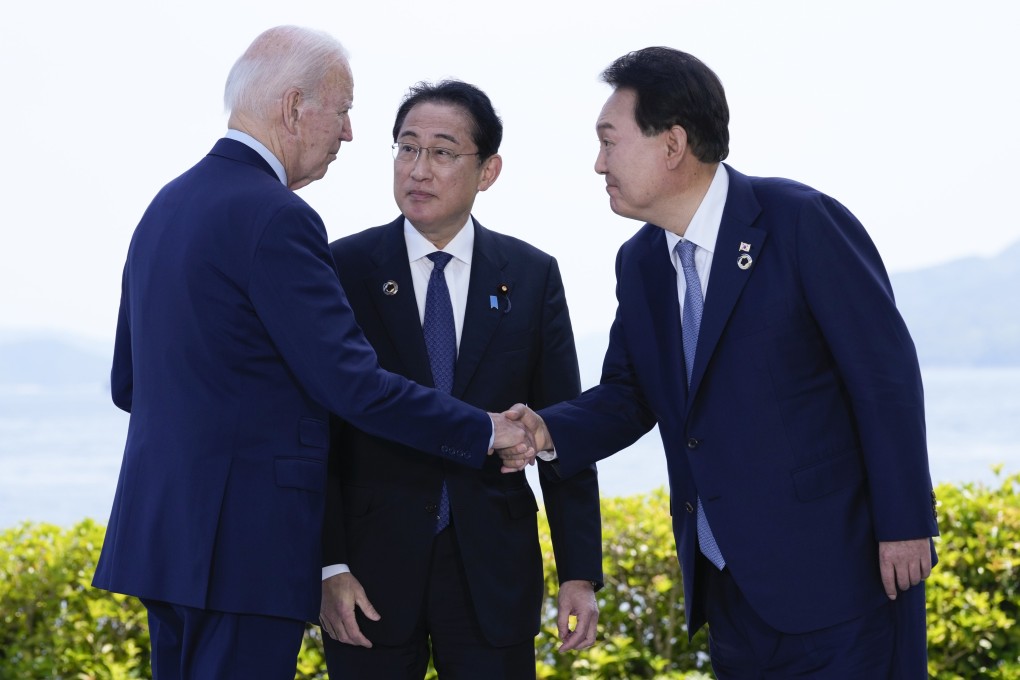 US President Joe Biden shakes hands with South Korean President Yoon Suk-yeol as Japanese Prime Minister Fumio Kishida watches ahead of a trilateral meeting on the sidelines of the G7 summit in Hiroshima, Japan, on May 21. Photo: AP
