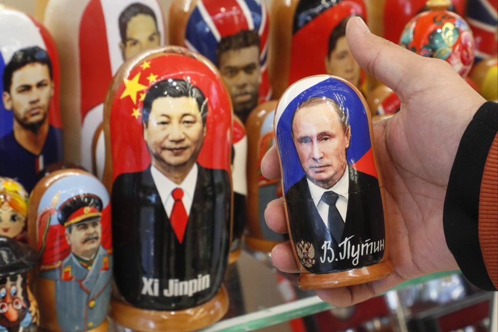 A man examines Russian matryoshka dolls with portraits of Russian President Vladimir Putin and Chinese President Xi Jinping at a street souvenir shop in Moscow in March. Photo: EPA-EFE
