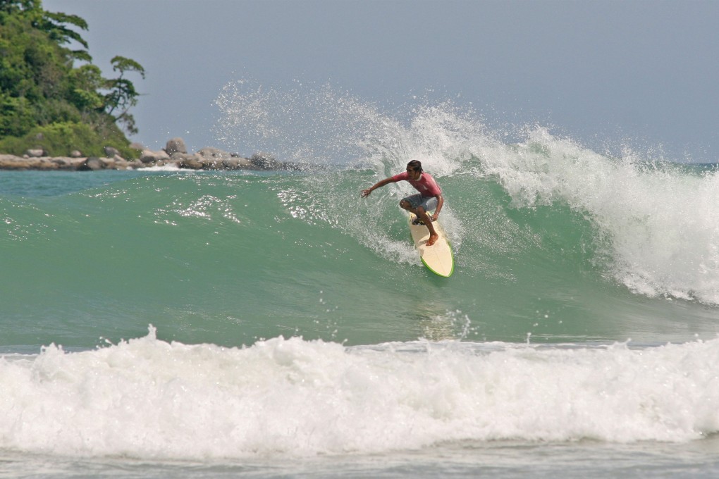 A surfer catches a wave in Phuket, Thailand. The island is making efforts to get in on the global surf tourism boom, which it could do as a place where novices can learn the sport. Photo: Shutterstock