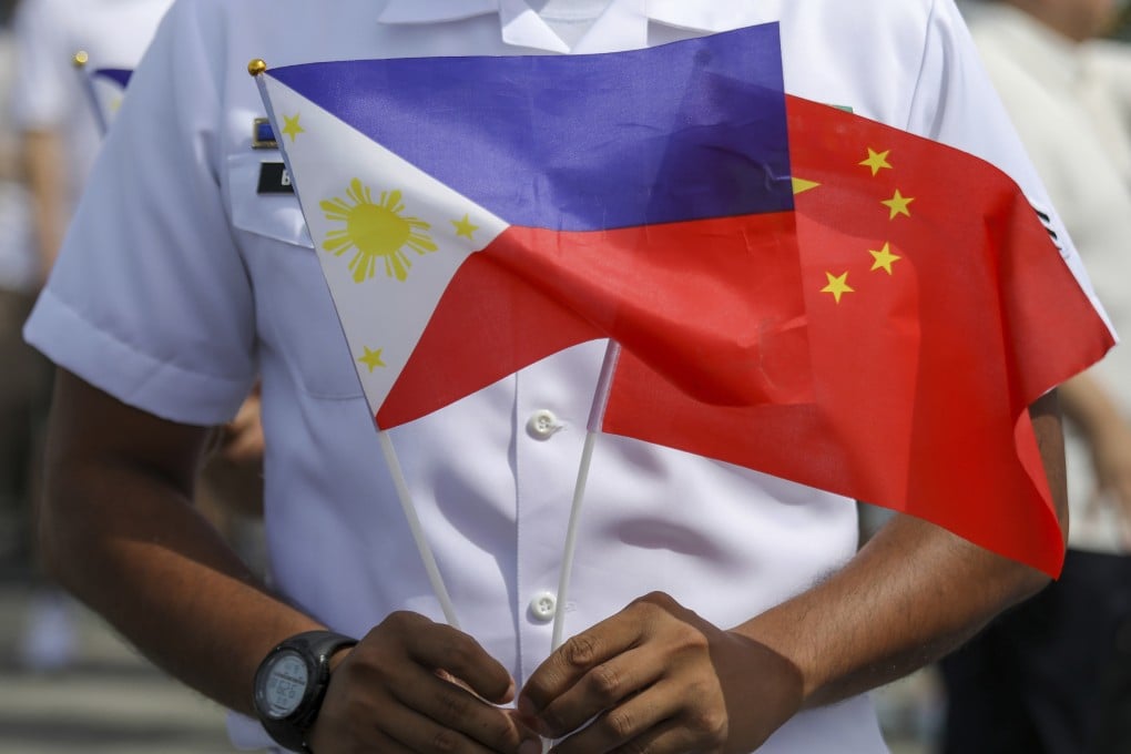 A member of the Philippine Coast Guard holds flags during the arrival of Chinese naval training ship, Qi Jiguang, for a goodwill visit at Manila’s port, Philippines, Wednesday, June 14, 2023. Photo: AP