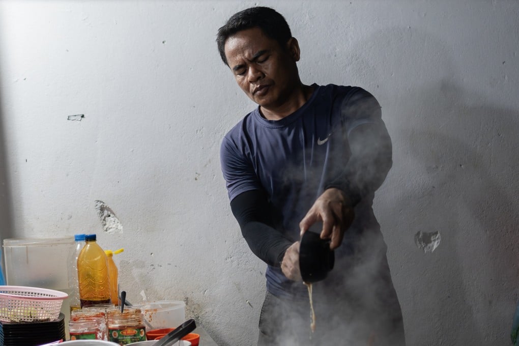 Chin Meas and his wife Kan Lida work at their noodle stand in Siem Reap, Cambodia. Cooking noodles 14 hours a day every day to make ends meet, renowned poet Meas struggles to find time to write poetry any more. Photo: Andy Ball