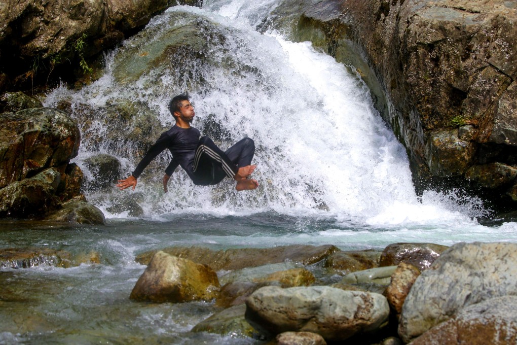 A Kashmiri teenager jumps into a stream to beat the heat on the outskirts of Srinagar, India, on July 5. Photo: EPA-EFE