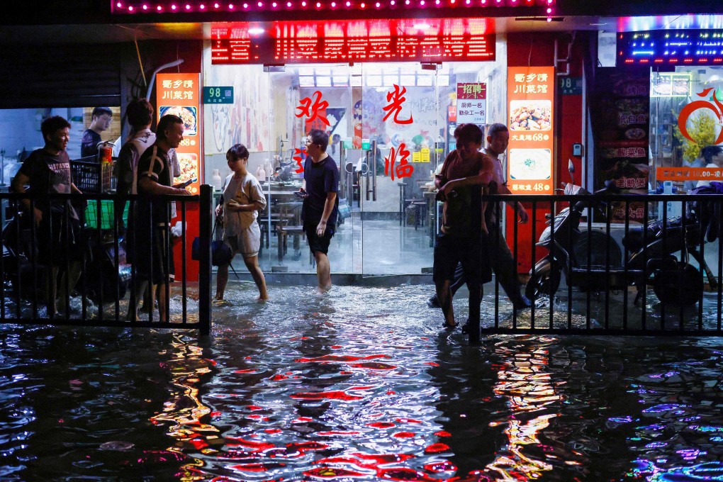 In this photo taken on July 21 people walk through a flooded street after heavy rains in Shanghai. Photo: AFP