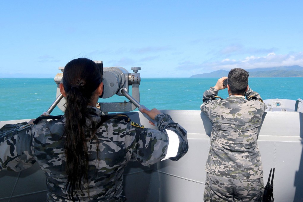 Australian sailors scan the ocean on Saturday for remnants of the crashed helicopter near Queensland’s Lindeman Island. Photo: Australian Defence Handout via AFP