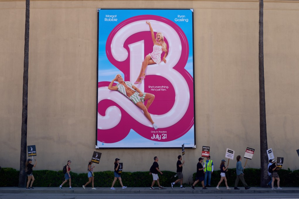 Striking actors and writers walk past a Barbie movie in front of Warner Bros. Studios in Burbank, California, on July 14. Photo: EPA-EFE