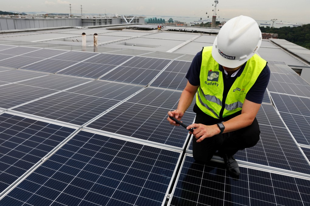 An employee inspects Keppel rooftop solar panels in Singapore. Singapore aims to achieve net-zero carbon emissions by 2050, but its small size and location present challenges for domestic production of renewable energy. Photo: Reuters