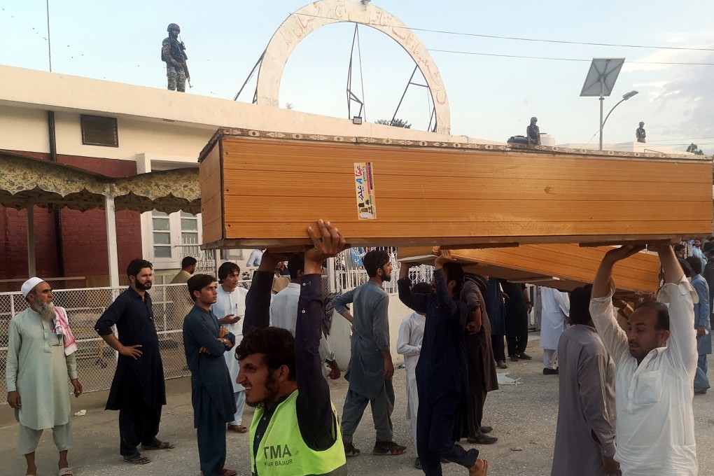 People carry coffins to collect the bodies of victims outside a hospital following an explosion in Bajaur, Pakistan on Sunday. Photo: EPA-EFE