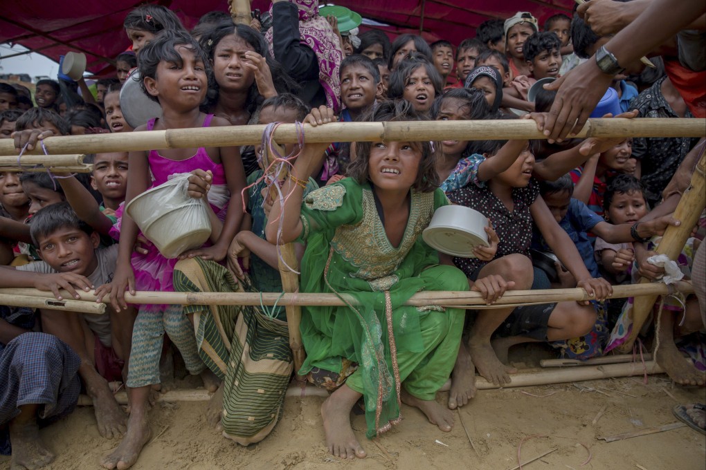 Rohingya children wait to receive food handouts in Bangladesh. Fearing arbitrary arrest by Indian authorities, some refugees were said to have fled from India to Bangladesh. Photo: AP