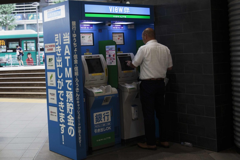 A man uses an ATM in Tokyo. Japanese police say scammers tricked people out of some US$105.1 million in the first half of this year. Photo: AFP
