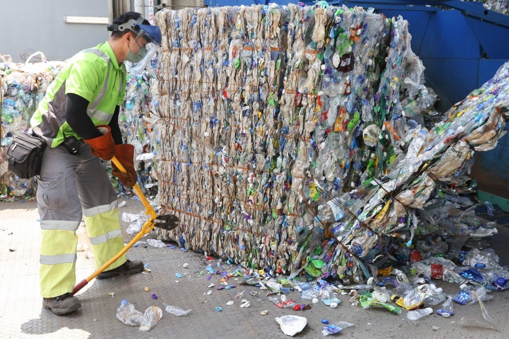 A worker transfers recycled plastic bottles to a bale breaker at New Life Plastics’ facility at EcoPark at Tuen Mun on September 6, 2022. The plant ceased operations in April after consistently running well below capacity because there were not enough plastic bottles to recycle. Photo: K.Y. Cheng