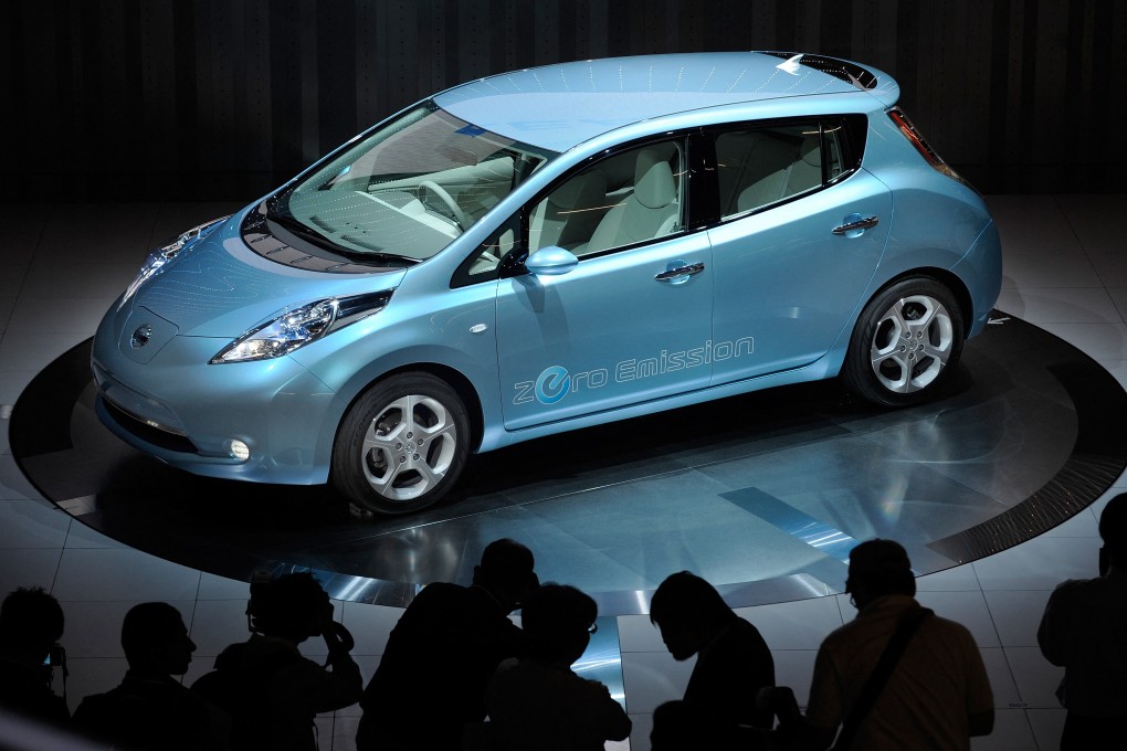 Photographers take pictures of Nissan Motor’s electric vehicle called “Leaf”. Photo: AFP