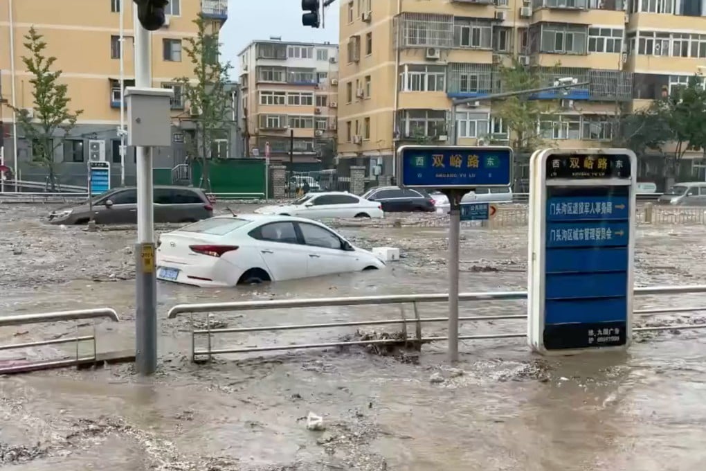 Cars are partially submerged as water gushes onto a flooded street in Beijing, after Typhoon Doksuri brought heavy rain, July 31, 2023. Photo: Reuters