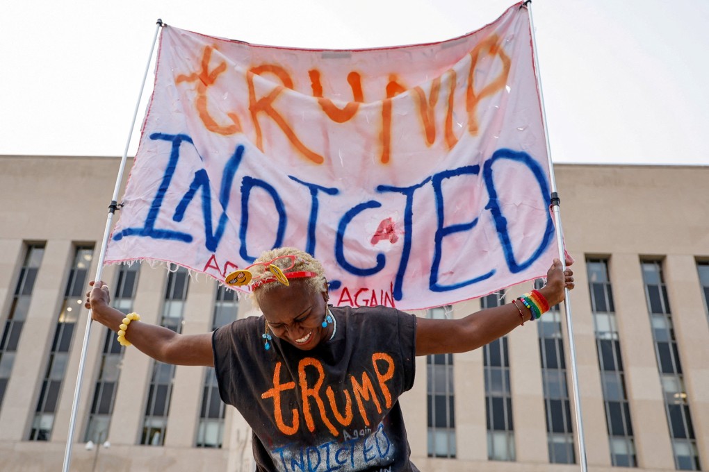 Nadine Seiler holds a banner in front of the federal courthouse where Donald Trump is expected later this week to answer new charges. Photo: Reuters