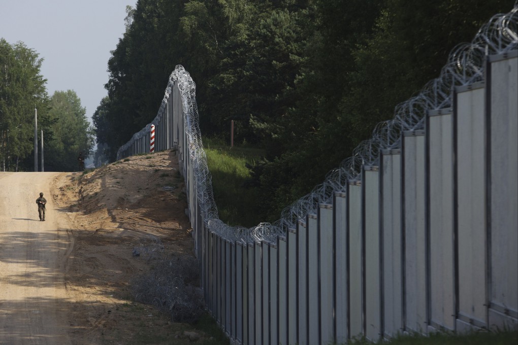 A Polish border guard patrols a metal wall on the border between Poland and Belarus in June. Photo: AP