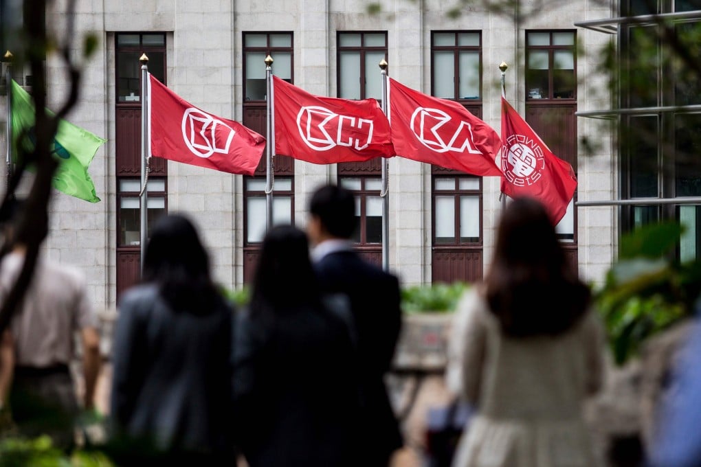 People walk near flags of CK Hutchinson Holdings outside the company’s headquarters in Hong Kong on March 21, 2019. Photo: AFP