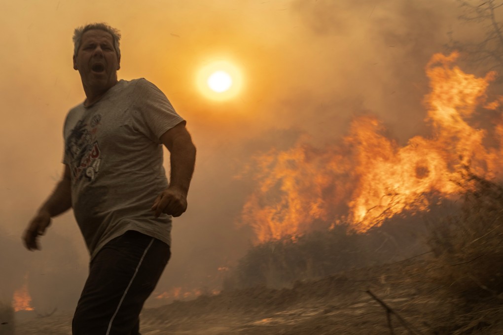 A local man reacts as trees burn in Gennadi village on the Aegean Sea island of Rhodes in southeastern Greece on July 25. Photo: AP