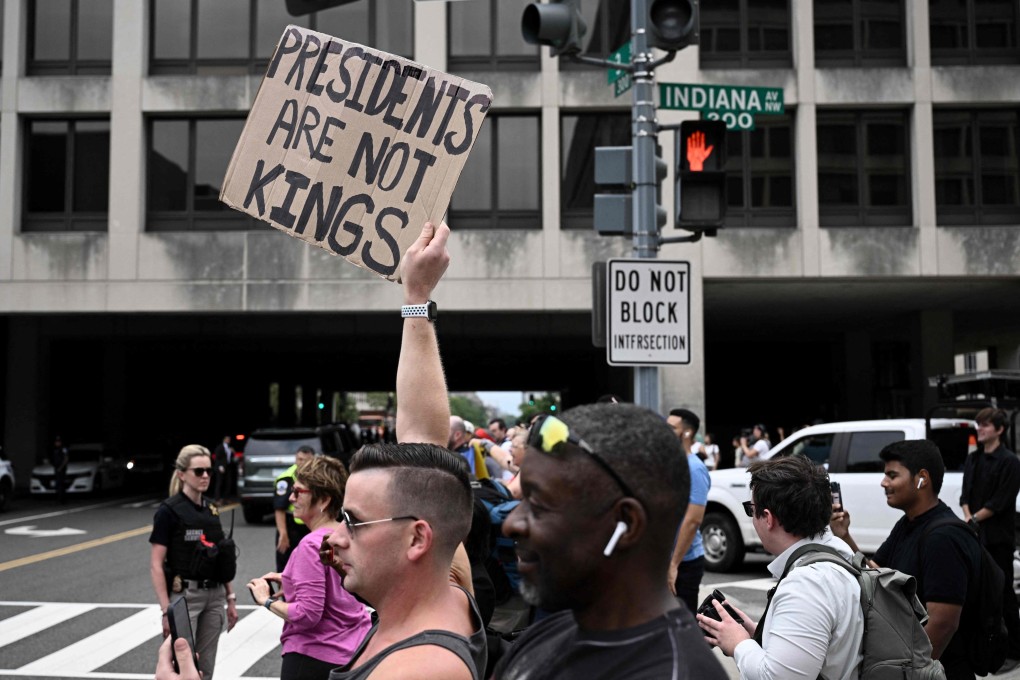 A demonstrator holds a sign reading “presidents are not kings” as he protests outside the federal courthouse in Washington on Thursday. Photo: AFP