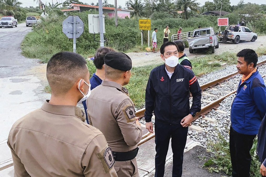 State Railway of Thailand governor talks to police at a crash site in Muang, Chachoengsao province. The pickup truck that collided with the train is in the background. Photo: AP
