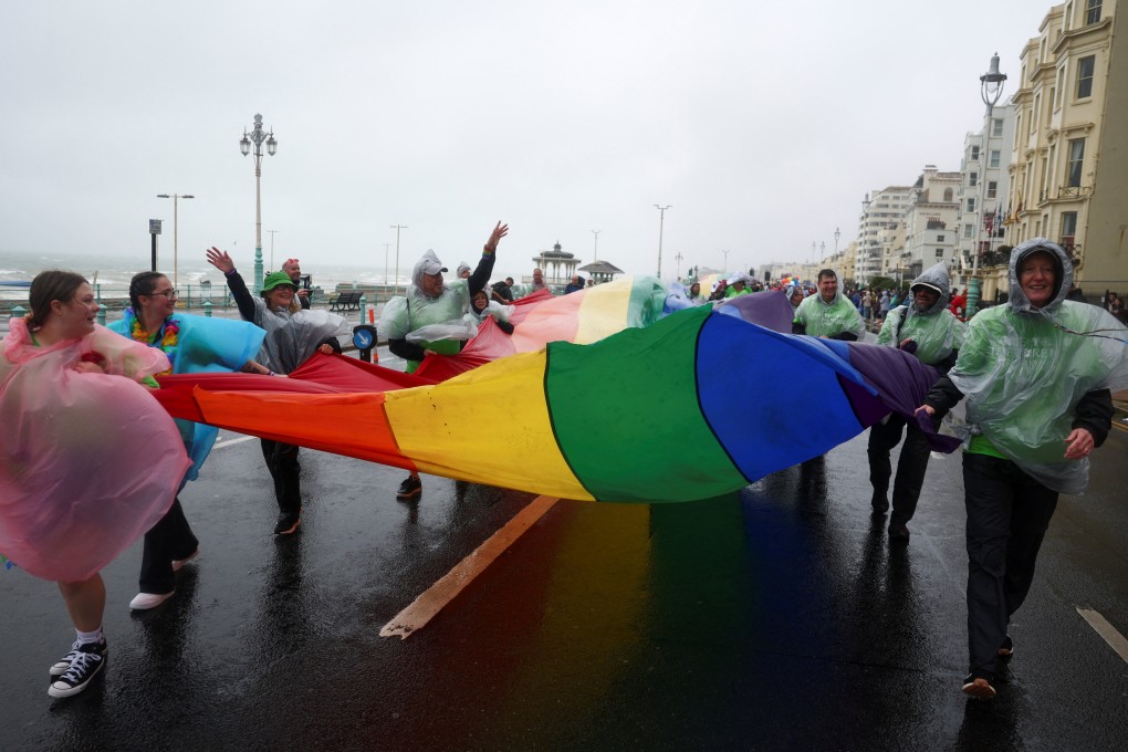 Participants in the annual International Pride Festival in Brighton, England struggle to hold a rainbow flag amid stormy weather. Photo: Reuters