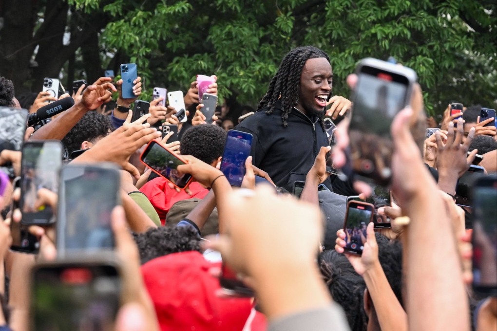 Twitch streamer Kai Cenat, centre, is surrounded by fans in New York on Friday. Photo: Getty Images / AFP