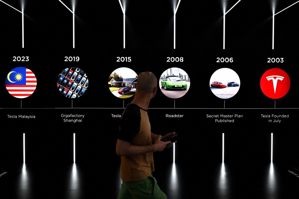 A man walks in front of Tesla banners in Kuala Lumpur on July 20. Photo: AFP