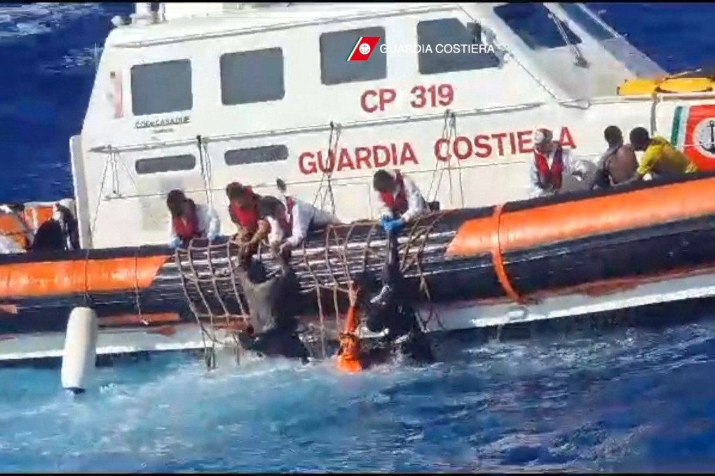 Rescuers help migrants to board a rescue boat during operations south of Lampedusa, Italy on Sunday. Photo: Italian Coastguard / Guardia Costiera / AFP