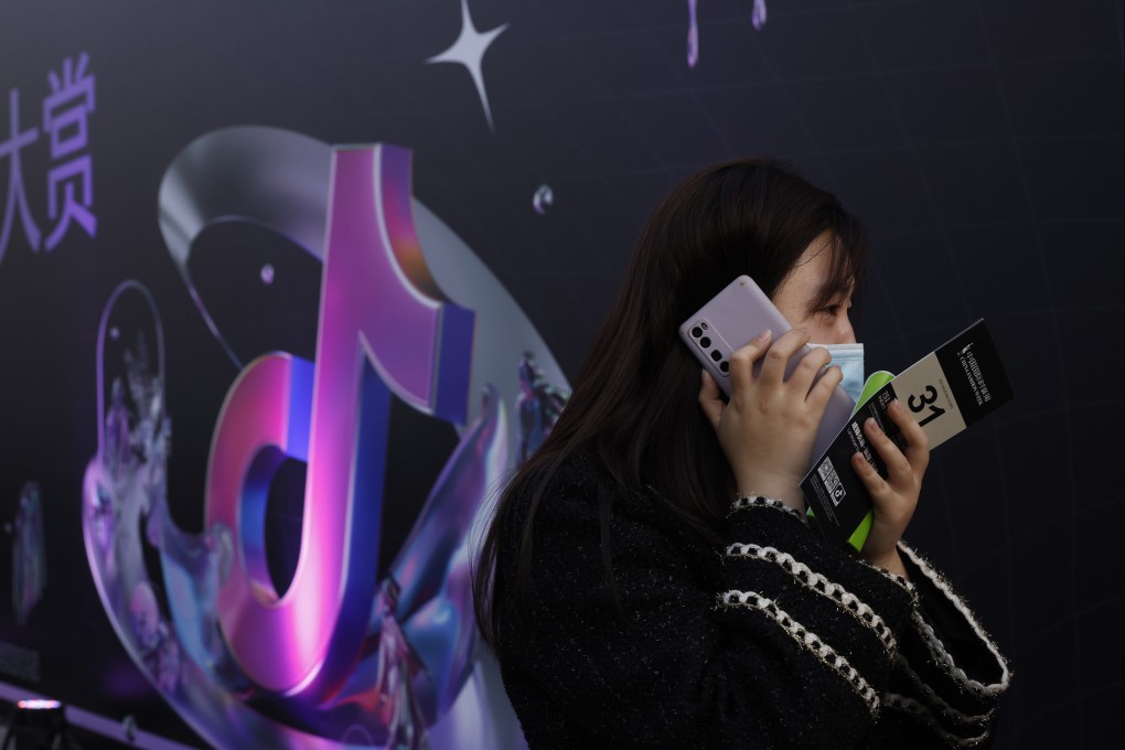 A woman speaks on her phone near the logo for Douyin in Beijing on Wednesday, March 31, 2021. Photo: AP