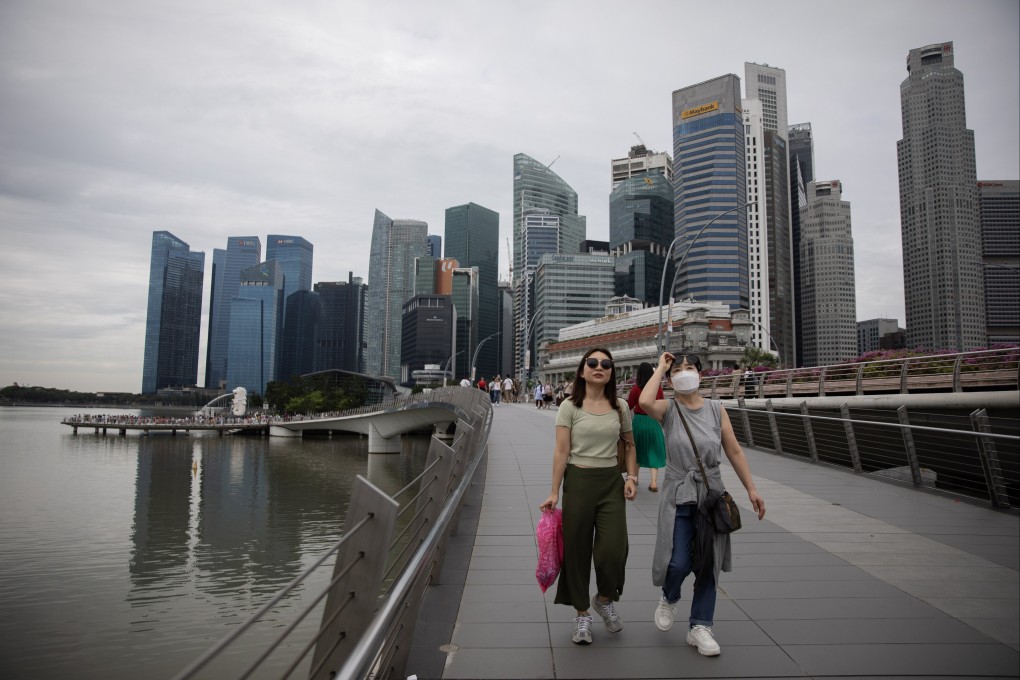 People take in the view along Singapore’s waterfront in the island state’s central business district. Photo:  EPA-EFE