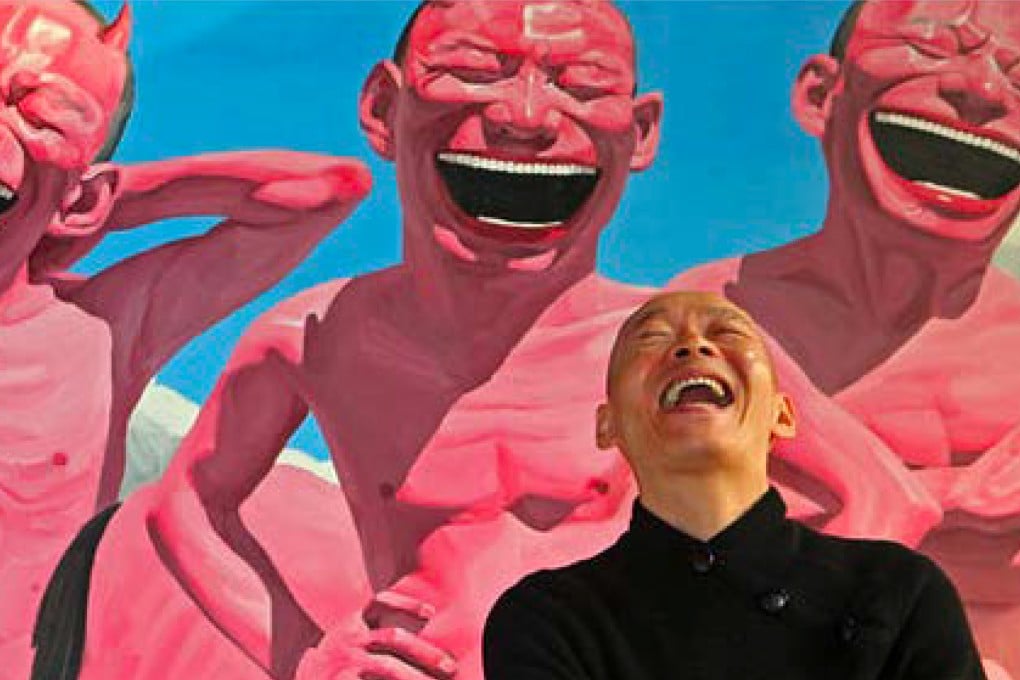 Chinese artist Yue Minjun posing in front of one of his “Laughing Man” paintings. His alter ego features in a collection of NFTs that are launching with the digital token market crashing, but he says his will have long-term value. Photo: Michelle Yue