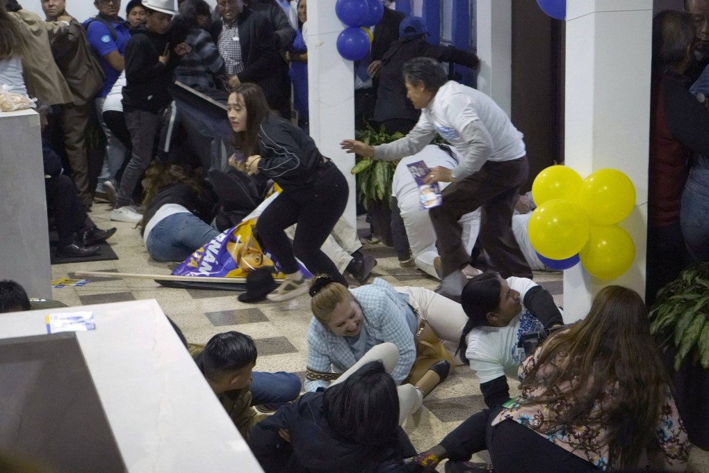 People take cover after shots were fired at the end of a rally of Ecuadorian presidential candidate Fernando Villavicencio in Quito. Photo AFP