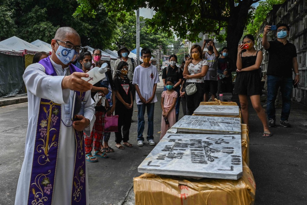 Father Flaviano Villanueva, who appears in filmmaker Sheryl Rose Andes’ new documentary Maria, prays with the relatives of drug war victims during an exhumation ceremony at Bagbag Cemetery in Metro Manila. More than 6,000 people were killed in police anti-drug raids during Rodrigo Duterte’s six-year term. Photo: AFP