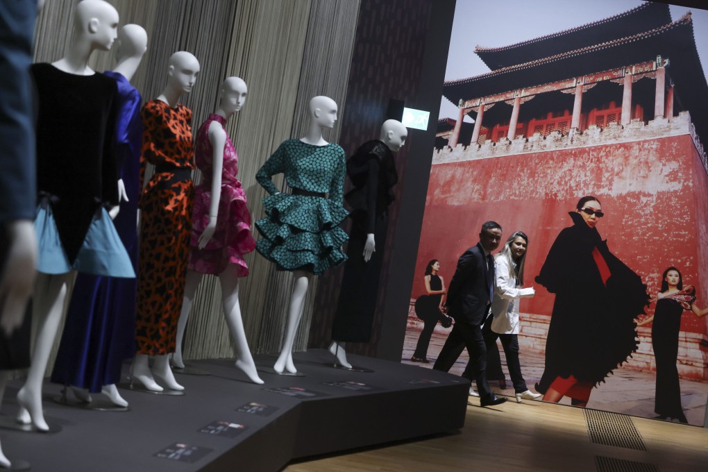 Dresses by Pierre Cardin, whose fashion Song Huai-kuei helped promote in China, are displayed at the M+ museum next to a blown-up photo by Yonfan of Song leading a fashion shoot at Beijing’s Forbidden City circa 1980 with models she trained. Photo: May Tse
