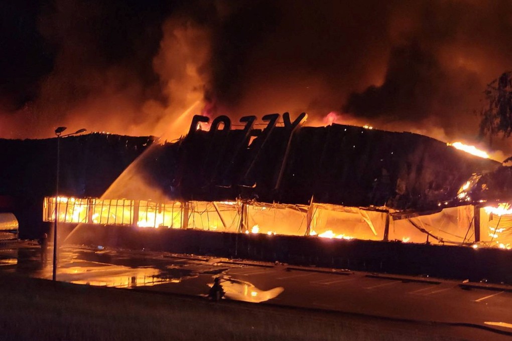 Firefighters work to put out a fire at a supermarket on Monday during one of the Russian drone and missile strikes. Photo: Handout via Reuters