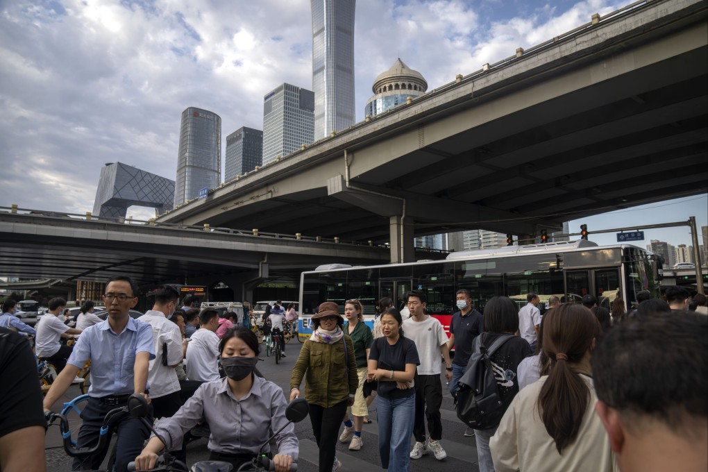 Commuters walk across an intersection during the evening rush hour in the central business district in Beijing on June 13, 2023. Photo: AP