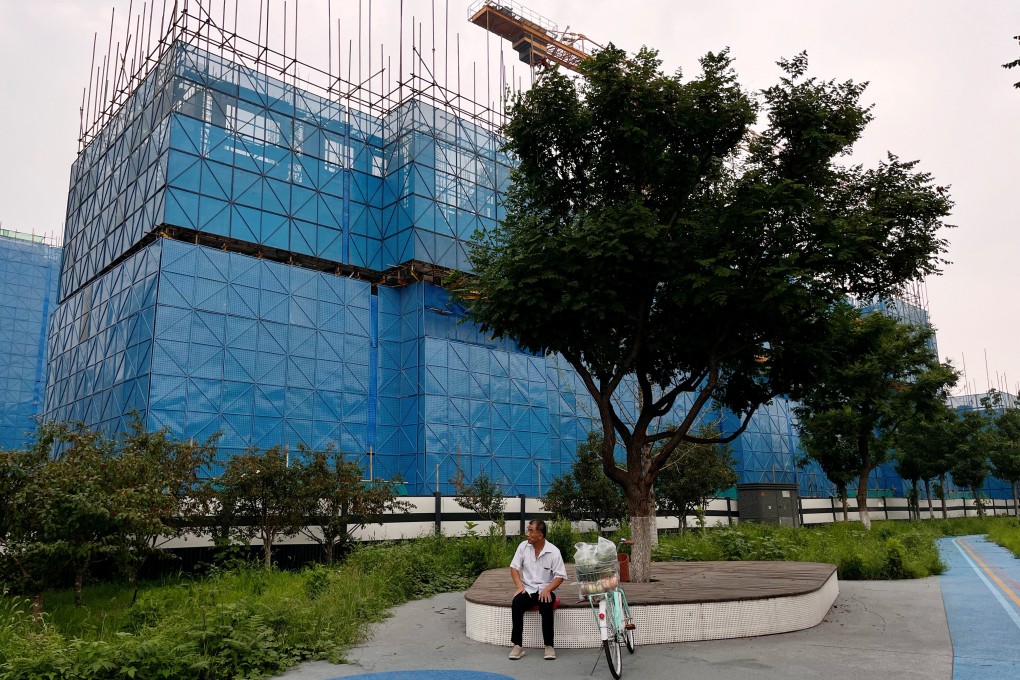 A person sits near a construction site of residential buildings by Chinese developer Country Garden in Beijing on August 11, 2023. Photo: Reuters