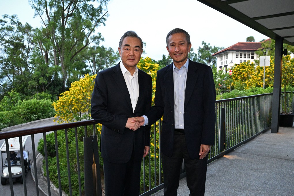 Chinese foreign minister Wang Yi (left) removes his tie for dinner with his Singapore counterpart Vivian Balakrishnan. Photo: Xinhua