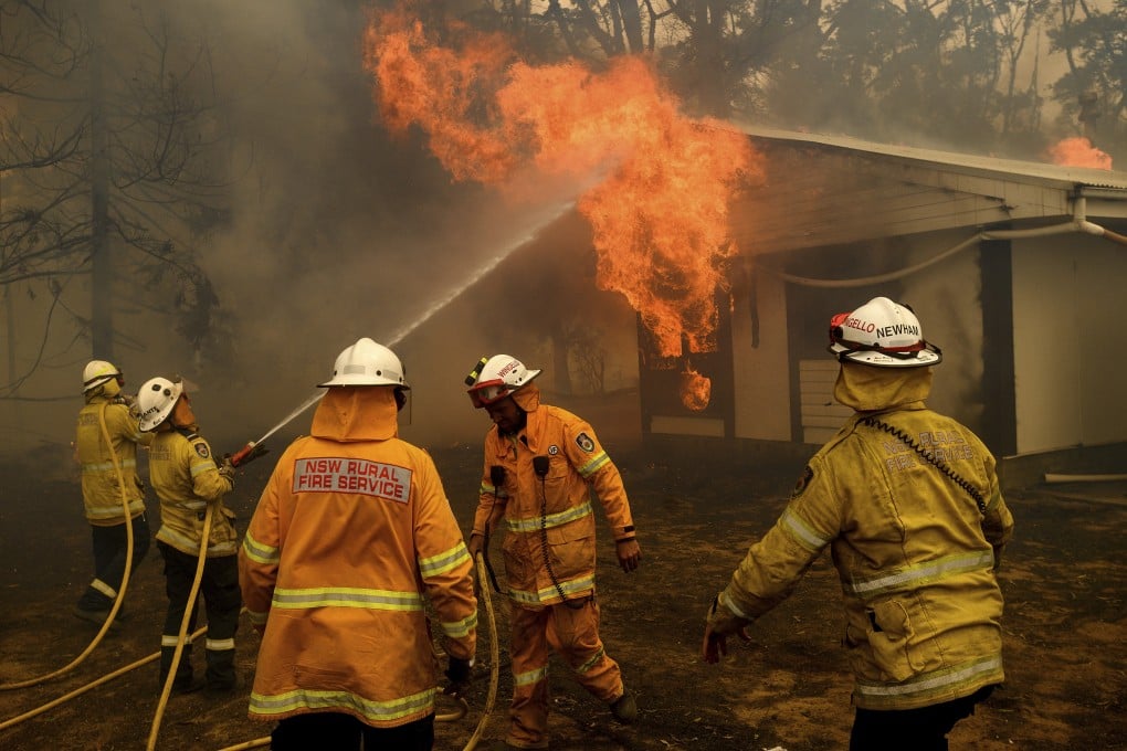 Australian firefighters attempt to extinguish a blaze at a house caused by a bush fire in New South Wales in 2020. Home insurance premiums for the highest-risk properties — such as those in flood or fire-prone areas — have shot up 50 per cent. Photo: AP