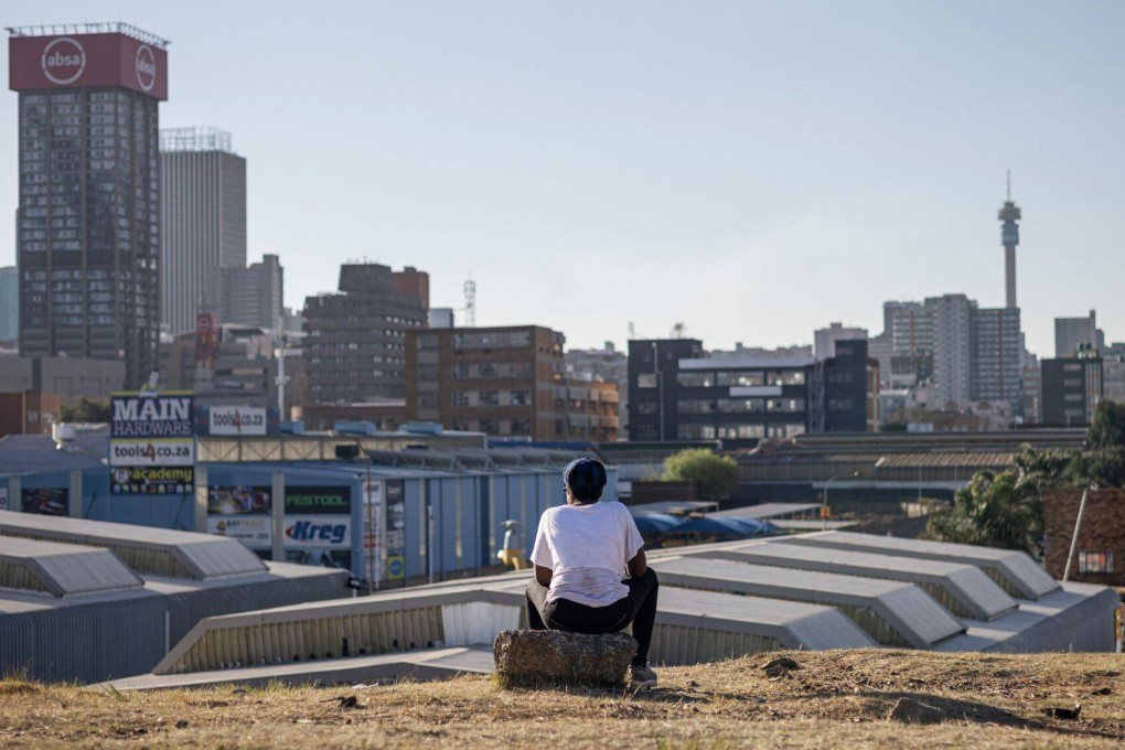 A resident looks out towards the skyline of the central business district in Johannesburg, South Africa, on August 15. The Brics summit will take place in the city from August 22-24, with plans to expand the bloc’s membership encountering resistance over concerns about diluting influence and complicating policymaking. Photo: Bloomberg