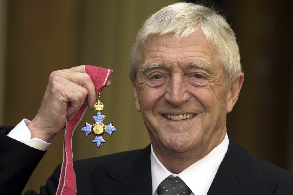 Michael Parkinson poses for the media after being awarded a CBE at Buckingham Palace in 2000. Photo: AP