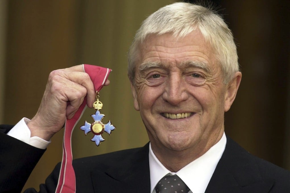 Michael Parkinson poses for the media after being awarded a CBE at Buckingham Palace in 2000. Photo: AP