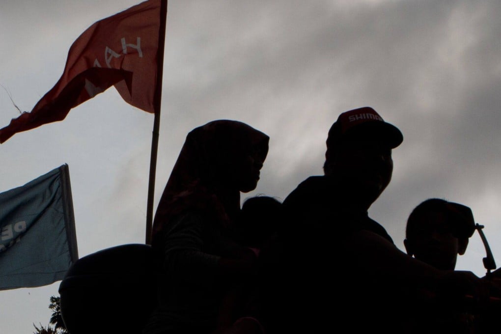 The flags of Perikatan Nasional party and Pakatan Harapan near a polling station in Selangor on August 12. Photo: Bloomberg