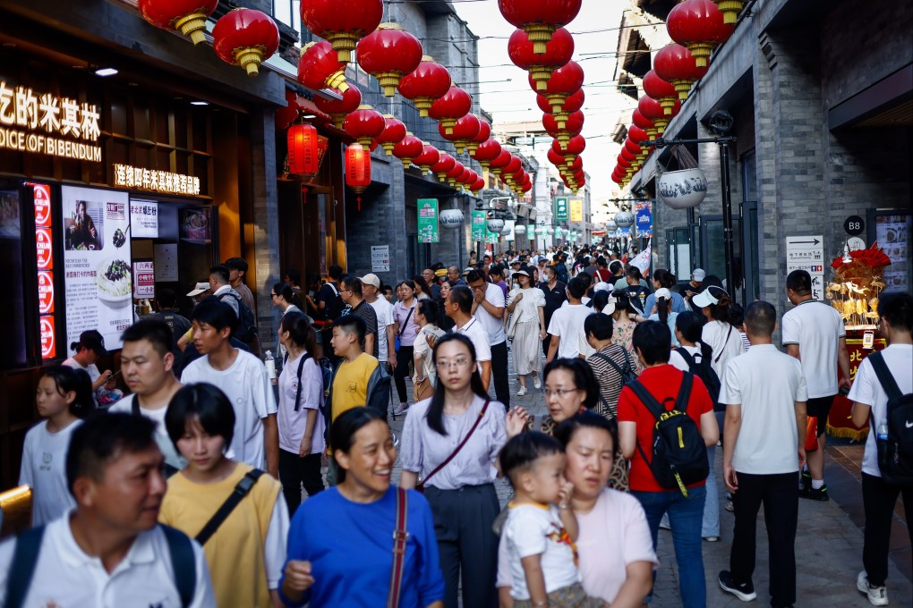 People walk through a shopping district in Beijing on July 25. Some economists argue that China’s economic woes are rooted in the population’s high savings rate. Photo: EPA-EFE