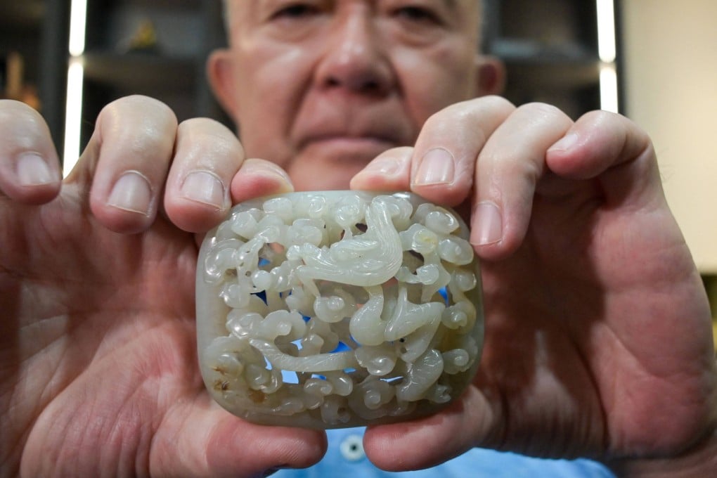 Chang Juben, chairman of Taiwan’s Association of Jade Collectors, holds a Yuan dynasty jade belt ornament showing a carving of a dragon among clouds, in Taipei, on July 19, 2023. Taiwan’s antique jade market is flagging post-Covid, partly due to Taipei’s worsening ties with Beijing. Photo: AFP