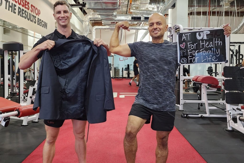 Singapore IT executive Avinash Gowda shows off his slimline form as personal trainer Owen Bisman holds up a now much too large jacket. Strength and cardio training, a keto diet, intermittent fasting, drinking less alcohol and quitting smoking helped Gowda shed 29kg. Photo: Avinash Gowda